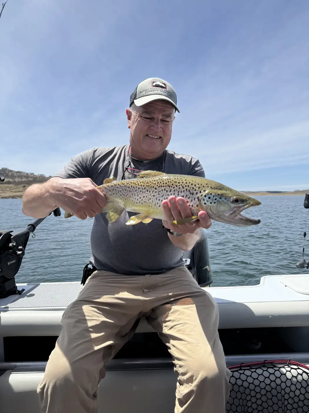 Mick with a big brown trout on the boat
